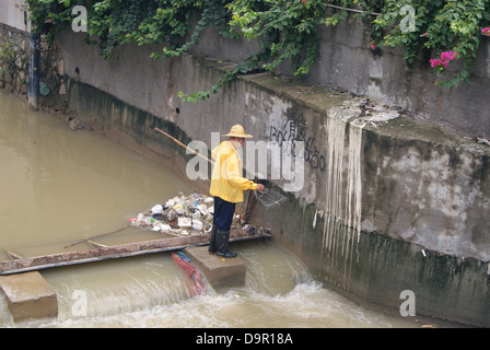 Un lavoratore nel fiume di dragaggio in Shenzhen, Cina Foto Stock