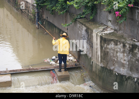 Un lavoratore nel fiume di dragaggio in Shenzhen, Cina Foto Stock