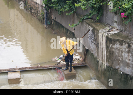 Un lavoratore nel fiume di dragaggio in Shenzhen, Cina Foto Stock