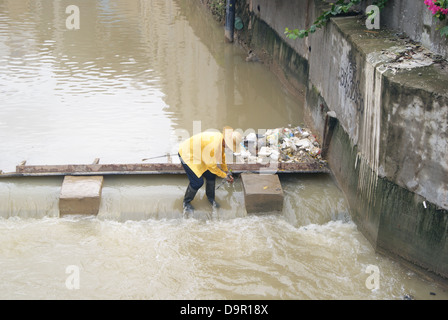 Un lavoratore nel fiume di dragaggio in Shenzhen, Cina Foto Stock