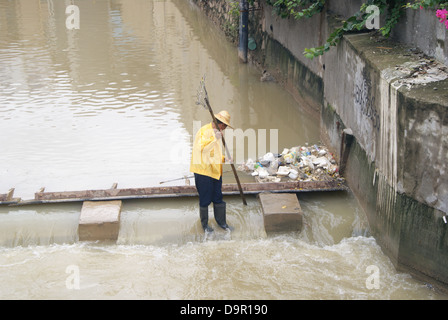 Un lavoratore nel fiume di dragaggio in Shenzhen, Cina Foto Stock