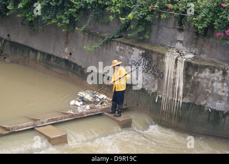 Un lavoratore nel fiume di dragaggio in Shenzhen, Cina Foto Stock