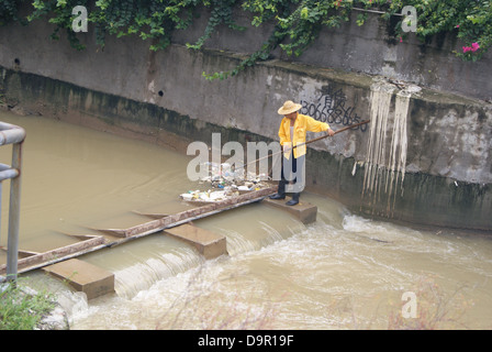 Un lavoratore nel fiume di dragaggio in Shenzhen, Cina Foto Stock