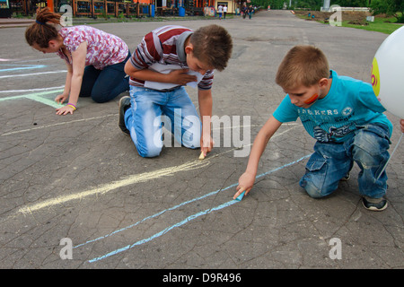 Disegno con matite colorate su asfalto. Foto Stock