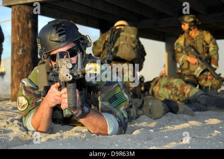 Un US Navy Special Warfare lottatori-craft Crewman dalla Barca Speciale Team 12 mantiene un look out mentre i suoi compagni di squadra trattare un ferito il suo compagno di squadra nel corso di un esercizio di formazione Dicembre 10, 2008 at Naval Special Warfare Center, CA. Foto Stock