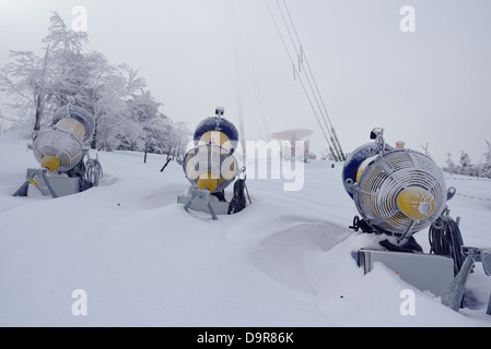 Cannoni da neve su un lato di una pista da sci Foto Stock