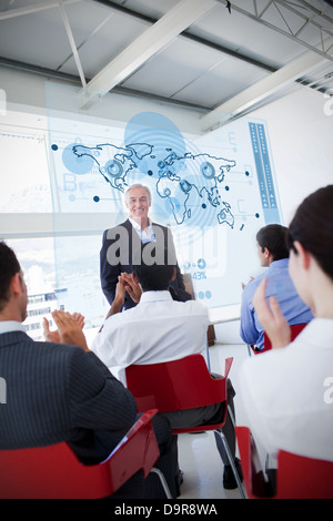 La gente di affari battimani stakeholder in piedi di fronte a mappa interfaccia schema Foto Stock