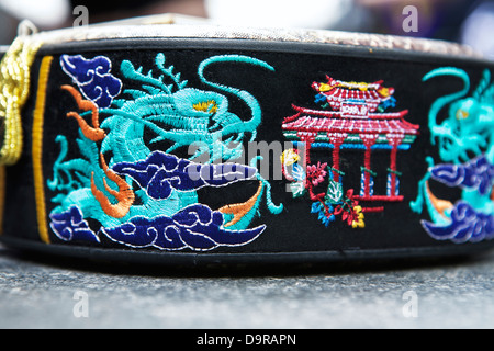 Il lato di un Sanshin, a tre corde tradizionale strumento musicale di Okinawa, ricamato con un drago blu e rosso tempio Foto Stock
