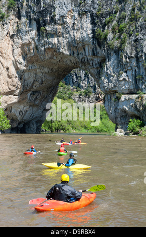 Persone in canoa sul fiume Ardeche nel canyon gole d'Ardèche in prossimità di un ponte naturale di roccia vicino Vallon-Pont-d'Arc, Francia Foto Stock