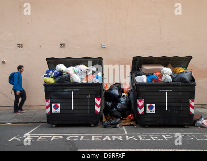 Brighton residenti a piedi passato sempre crescente cumuli di rifiuti nelle strade,durante uno sciopero da parte della città di rifiutare i lavoratori Foto Stock