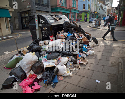 Brighton residenti a piedi passato sempre crescente cumuli di rifiuti nelle strade,durante uno sciopero da parte della città di rifiutare i lavoratori Foto Stock