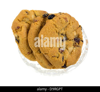 Un piccolo piatto di vetro riempito con il cioccolato bianco chip gourmet a base di mirtillo palustre i cookie su uno sfondo bianco. Foto Stock