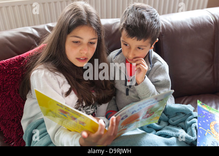 Sorella la lettura di una storia di suo fratello Foto Stock