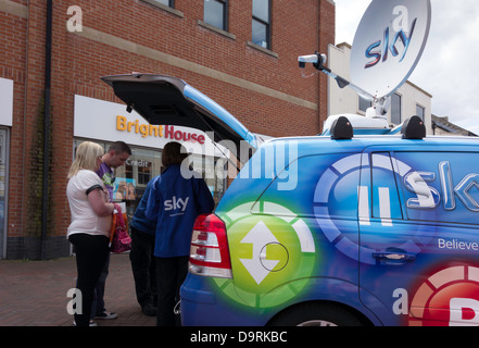 I rappresentanti di Sky Television la vendita di un servizio a un giovane in strada alta. Foto Stock