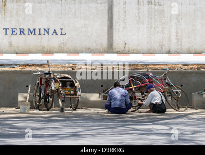 Riparazione di tricicli in strada Foto Stock