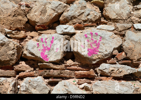 Per bambini handprint sul muro di pietra in vernice rosa Foto Stock