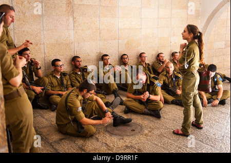 Israele Gerusalemme vecchia città armati del gruppo giovani maschi IDF soldati israeliani in uniforme essendo informato dal responsabile della femmina Foto Stock