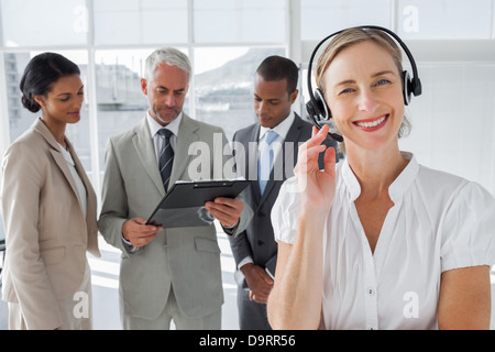 Donna sorridente in piedi con una cuffia Foto Stock