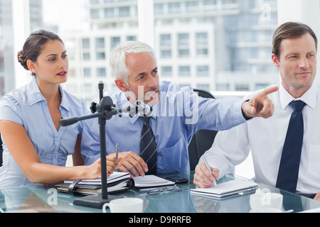 Uomo d'affari rivolto a qualcosa in una conferenza Foto Stock