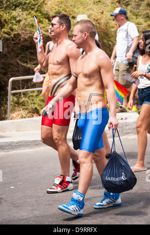 Israele Tel Aviv Gay Pride alle celebrazioni del Giorno parade due 2 ragazzi giovani uomini a piedi trunk in Lycra a Gordon Beach party parade marzo pageant scene di strada Foto Stock