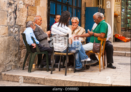 Israele città vecchia Gerusalemme scena di strada gruppo intenso di arabi uomini musulmani giocando a carte gioco di carte seduti attorno al tavolo di gioco Foto Stock