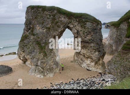 Free-standing arco sulla bianca spiaggia di rocce. Bushmills, costa di Antrim nella contea di Antrim. Irlanda del Nord, Regno Unito, Europa Foto Stock