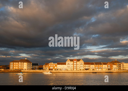 Nel tardo pomeriggio sun mette in evidenza uno sviluppo del waterfront homes accanto al fiume Adur nel West Sussex, in Inghilterra del sud. Foto Stock