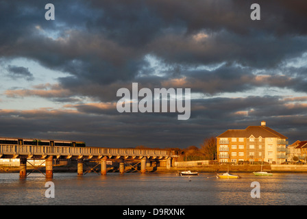 Nel tardo pomeriggio sun mette in evidenza uno sviluppo del waterfront homes accanto al fiume Adur nel West Sussex, in Inghilterra del sud. Foto Stock