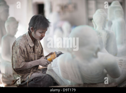 Una stone mason lavorando su marmo Buddha, Mandalay Myanmar (Birmania) Foto Stock