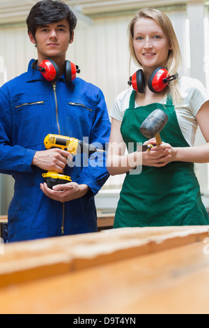 Due studenti di falegnameria in piedi davanti a un banco di lavoro Foto Stock