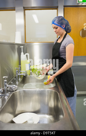 Donna che utilizza una spugna per piatti Foto Stock