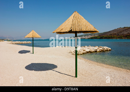 Bellissima spiaggia remota sul litorale Adriatico vicino a Trogir in Croazia con crystal clear calma invitando l'acqua. Foto Stock