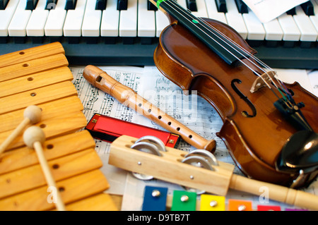 Strumenti musicali per bambini: xilofono, bambini, violino tamburello, flauto, armonica, tastiera di pianoforte. Foto Stock