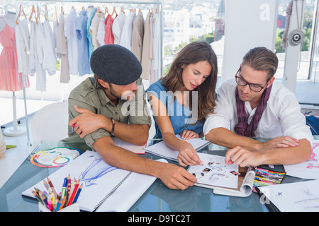 Tre fashion designer che lavorano in un ufficio luminoso Foto Stock