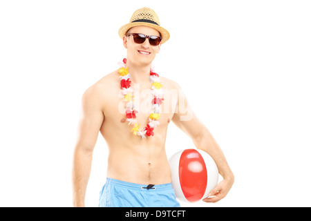 Montare l'uomo nel nuoto shorts, tenendo in mano una palla spiaggia Foto Stock