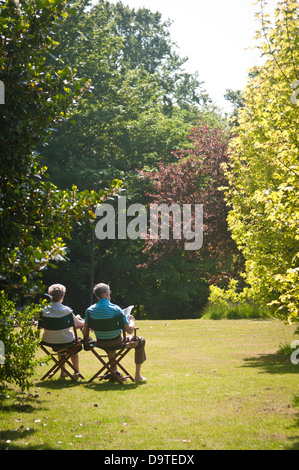 Un pensionato di coppia sposata godetevi l'estate britannica nel parco durante una ondata di caldo Foto Stock