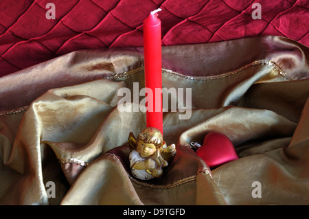 Candela con un piccolo angelo e cuore rosso pallina. Addobbi natale sfondo. Foto Stock