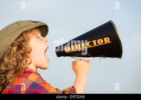 Kid gridando attraverso vintage megafono. Concetto di comunicazione. Uno stile rétro Foto Stock