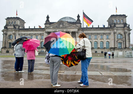 I turisti stand con ombrelloni di fronte al Reichstag di Berlino, Germania, 25 giugno 2013. Foto: OLE SPATA Foto Stock