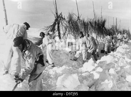 La Propaganda nazista! Sul retro dell'immagine si legge: 'Lotta contro la neve alta a nord. Il vento polare ghiacciato soffia sulla tundra! Le derive di neve rendono impraticabili le strade di approvvigionamento della truppa. La strada è sotto osservazione nemica. Le tende mimetizzazione le ostacolano.» Immagine dal fronte orientale/Russia, 6 aprile 1944. L'attacco all'Unione Sovietica da parte del Reich tedesco fu concordato nel luglio 1940 e preparato come "operazione Barbarossa" dal dicembre 1940. Il 22 giugno 1941 iniziò l'invasione della Wehrmacht tedesca. Fotoarchiv für Zeitgeschichte Foto Stock