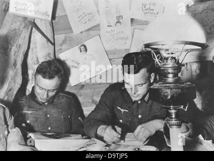 La Propaganda nazista! Sul retro dell'immagine si legge: 'Nel dugout. I nostri soldati si sono resi comodi nel cassero della posizione di fronte al Leningrado assediato. I disegni sul muro mostrano gli spiriti umorici dell'azienda." Un'immagine dal fronte orientale/Russia, 31 ottobre 1941. L'attacco alla Russia da parte del Reich tedesco fu concordato nel luglio 1940 e preparato dal dicembre 1940 come "operazione Barbarossa". Il 22 giugno 1941 iniziò l'invasione dell'Unione Sovietica da parte della Wehrmacht tedesca. Fotoarchiv für Zeitgeschichte Foto Stock