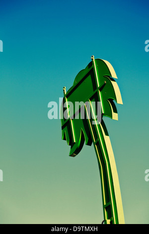 Invertire di metallo Palm tree in verde contro il cielo blu, parte di attrazione della fiera. Foto Stock