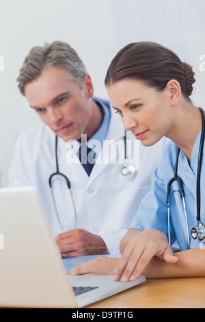 Due medici si è focalizzato su un schermo di computer portatile Foto Stock