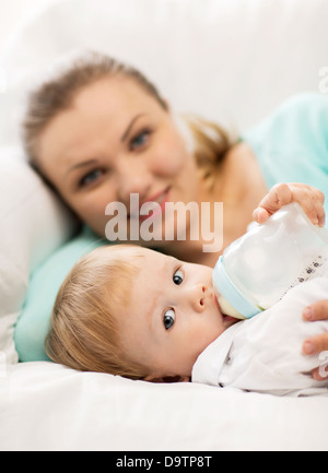 La madre e il bambino adorabile con biberon Foto Stock