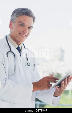 Capelli grigi medico sorridente Foto Stock