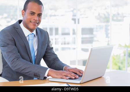 Allegro imprenditore lavorando sul suo computer portatile Foto Stock