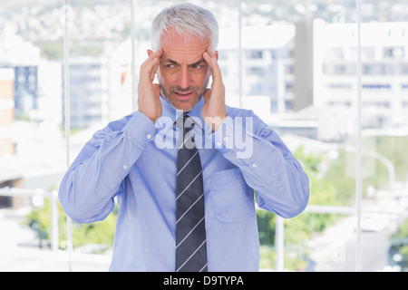 Sottolineato imprenditore strofinando il suo tempio Foto Stock