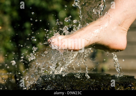 Schizzi di acqua fredda aveva infuso in piedi in una terapia alternativa sessione; gocce congelate Foto Stock