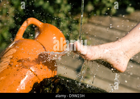 Schizzi di acqua fredda aveva infuso in piedi in una terapia alternativa sessione; gocce congelate Foto Stock