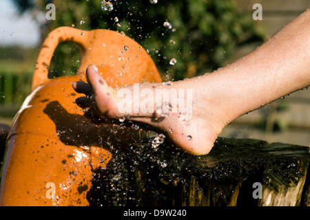 Schizzi di acqua fredda aveva infuso in piedi in una terapia alternativa sessione; gocce congelate Foto Stock